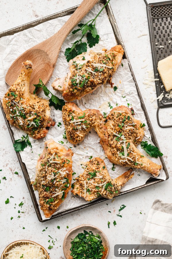 Crispy Oven Fried Parmesan Chicken on a plate, garnished with fresh herbs