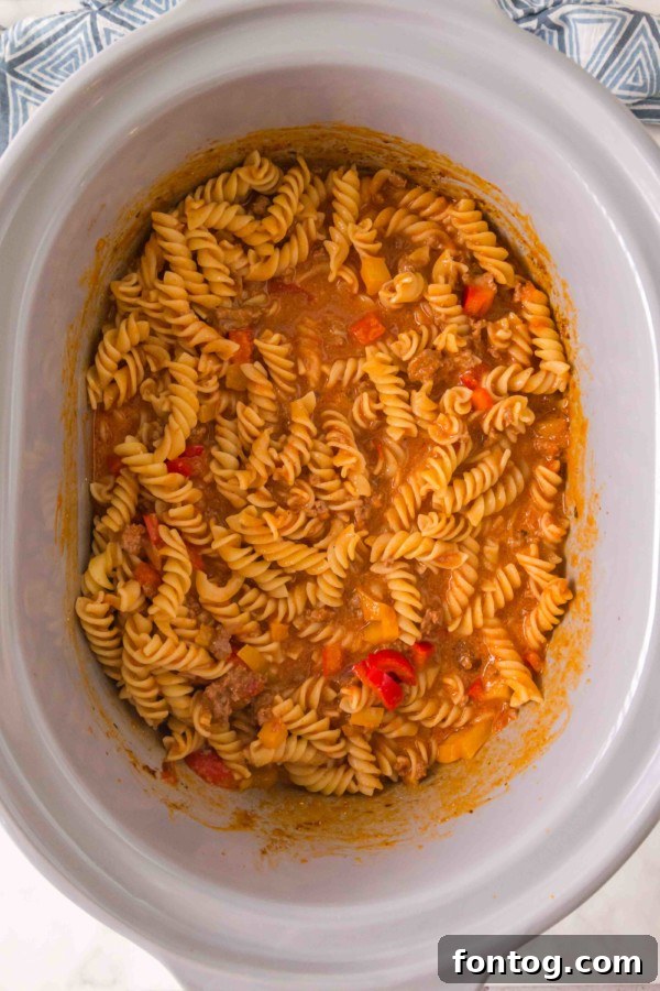 Cooking ground beef and onions for slow cooker taco pasta
