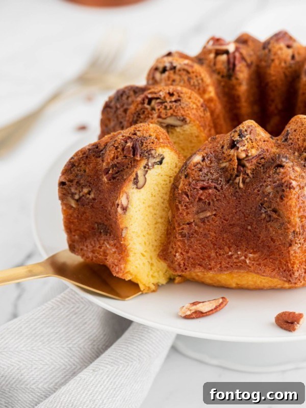 Slice of pecan rum cake on a white plate, perfect for Thanksgiving dessert