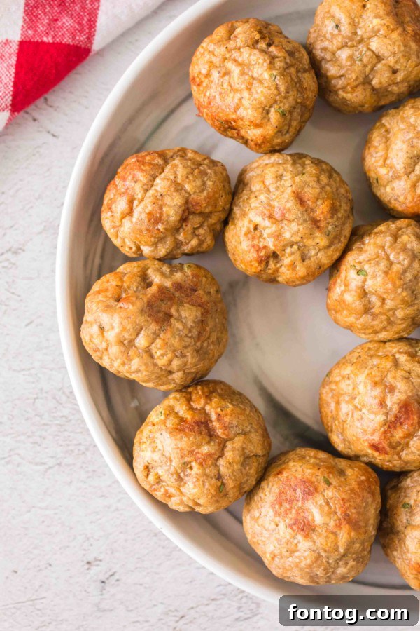 Close-up of baked gluten-free turkey meatballs with breadcrumbs on a baking sheet