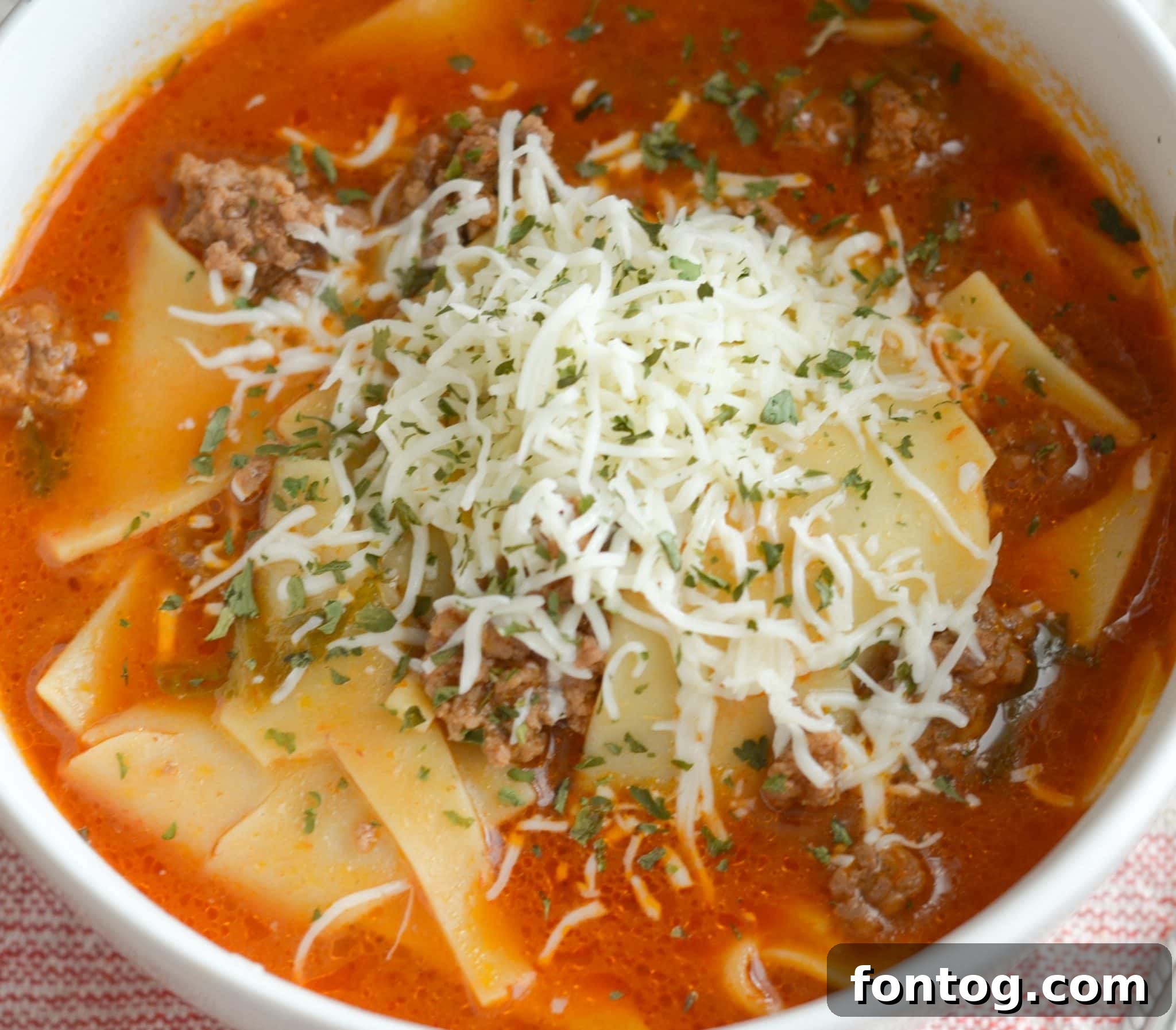 Lasagna soup in a bowl with cheese.
