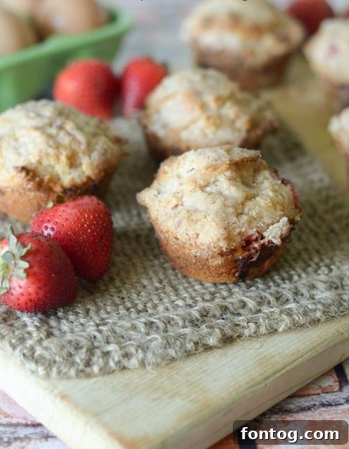 Freshly baked Strawberry Crumble Muffins, golden brown with a sweet topping.