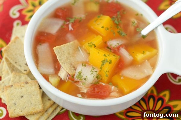 A rustic bowl of Slow Cooker Chicken & Vegetable Soup on a wooden table, emphasizing homemade comfort