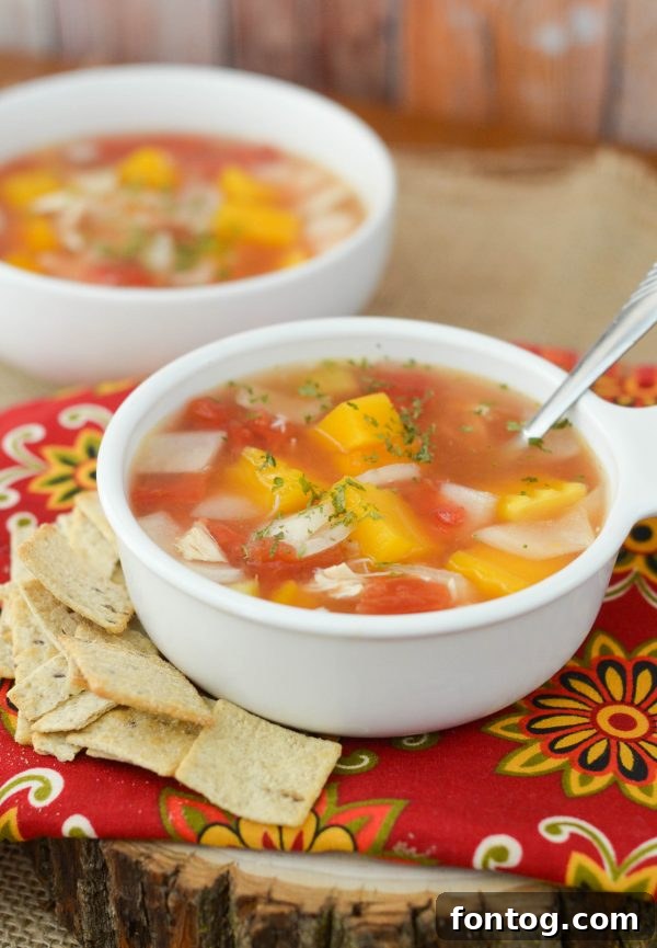 A full pot of Slow Cooker Chicken & Vegetable Soup simmering, showing the vibrant ingredients