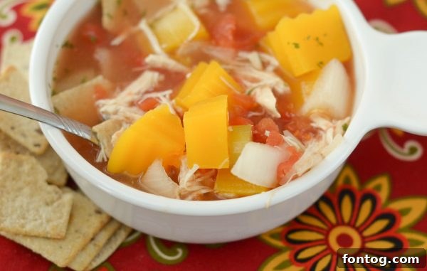 A close up of Slow Cooker Chicken & Vegetable Soup, garnished with fresh parsley, ready for a cozy meal