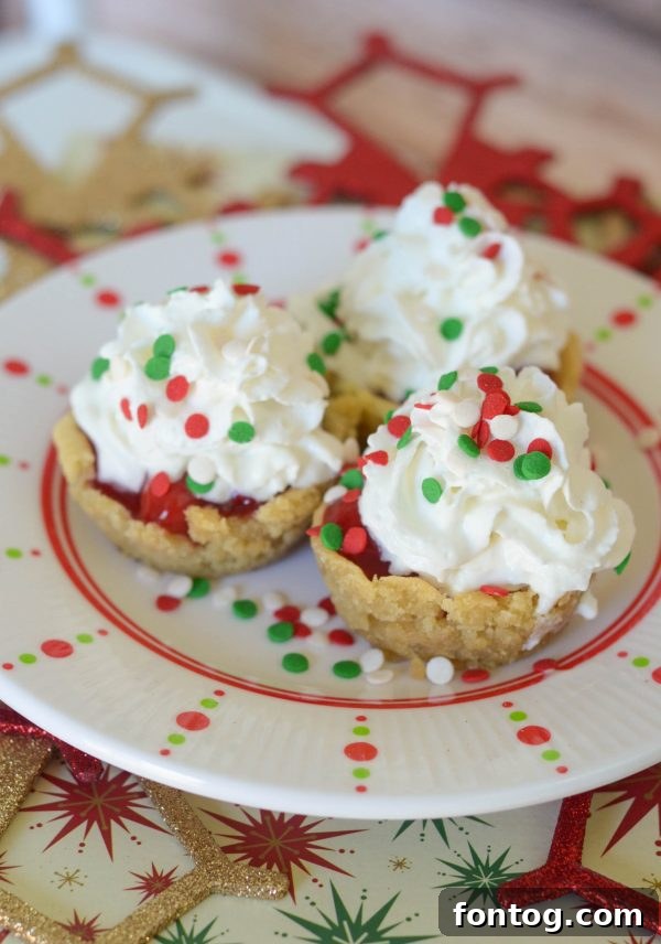 Freshly baked sugar cookie cups cooling in a muffin tin, after being reshaped with a scoop