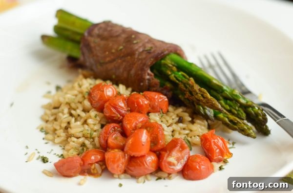 Savory Steak and Asparagus Bundles 5 Plated Steak Wrapped Asparagus with Wild Rice and Roasted Tomatoes