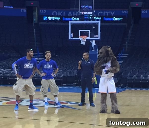 A wide shot showing Hill Harper addressing a large audience of young students, with a screen displaying #FutureSmart branding.