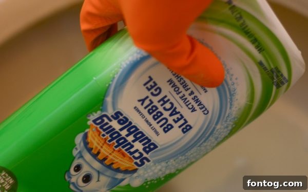 A toilet bowl cleaner bottle positioned to clean under the rim, showing the product in use.