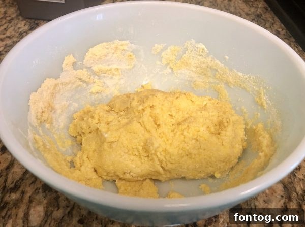 Scooping hush puppy batter and placing in an air fryer basket