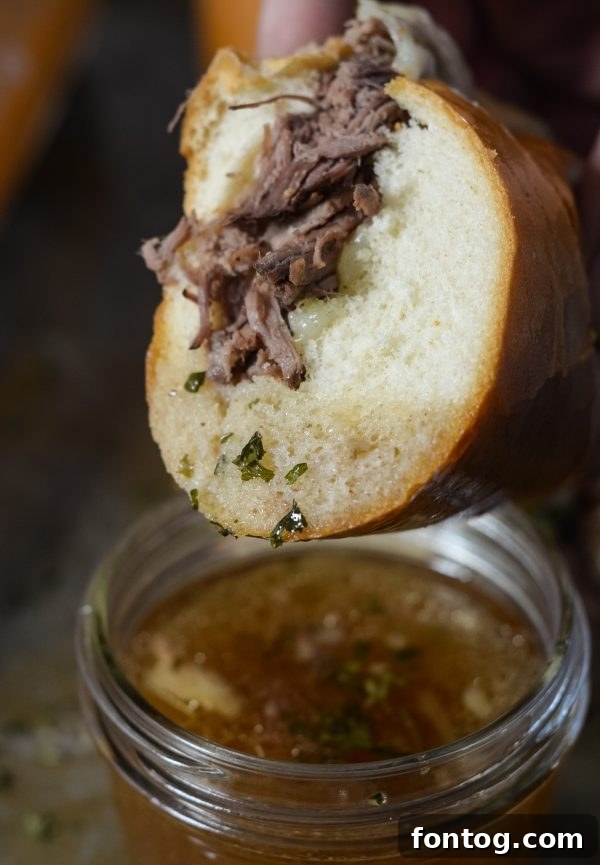 Close-up of a French Dip Sandwich showing tender beef and melted cheese