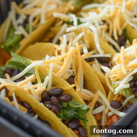 Crispy Air Fryer Tacos filled with seasoned meat, fresh lettuce, and cheese, ready for a quick and satisfying dinner.
