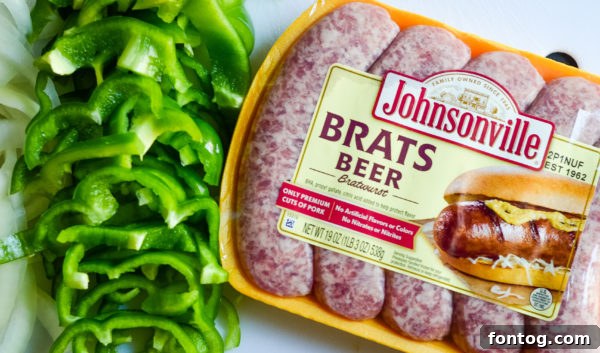 Close-up of Johnsonville Beer Brats in an air fryer basket with sliced onions and peppers