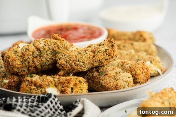 Golden & Gooey: Ninja Foodi Gluten-Free Mozzarella Sticks 6 A Ninja Foodi air fryer basket with golden brown mozzarella sticks.