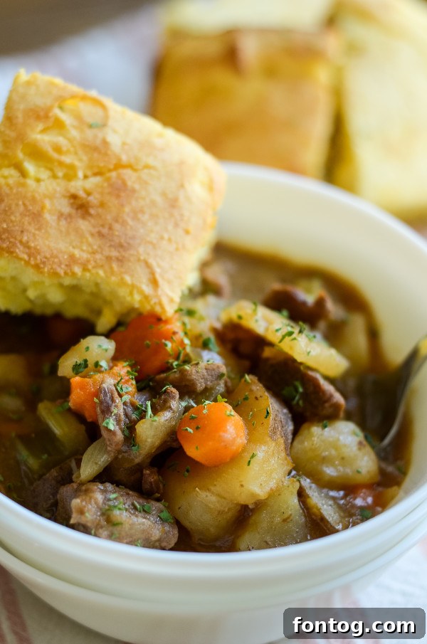 Gluten-Free Slow Cooker Beef Stew in a serving bowl, garnished with fresh herbs
