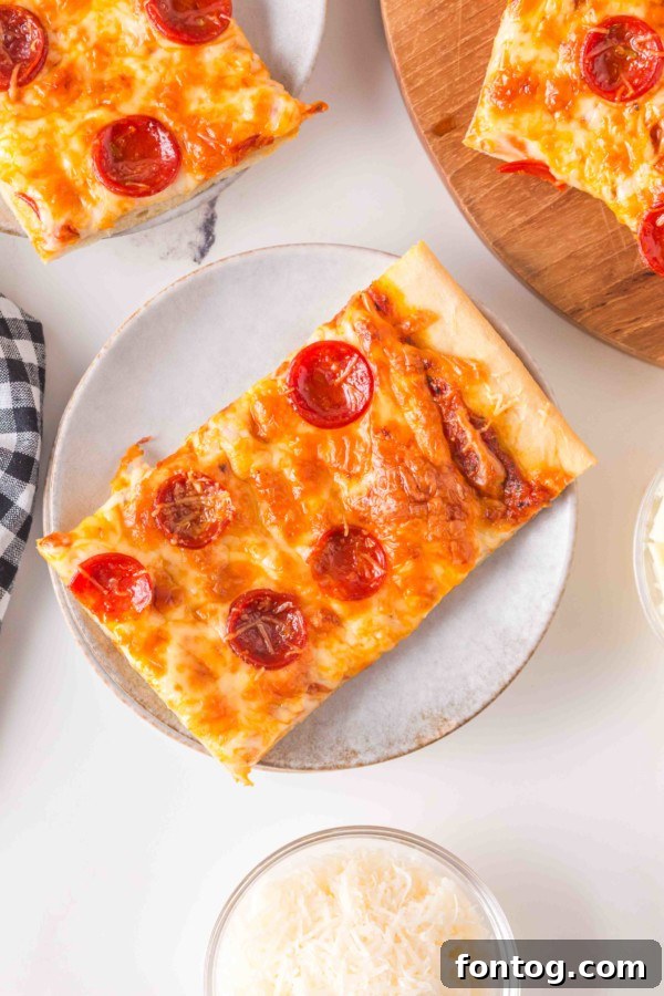 Sliced sheet pan pizza on a cooling rack, ready to serve.